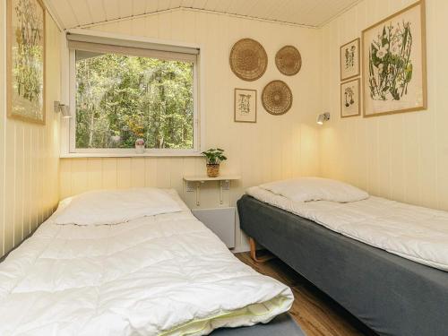 Dos camas en una habitación con ventana. en 6 person holiday home in Ålbæk, en Ålbæk