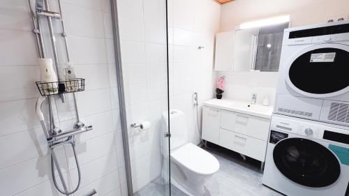 a bathroom with a shower and a toilet and a sink at Heart of Oulu studio Parking in Oulu