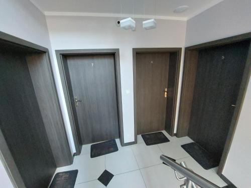 a bathroom with three glass doors and a tile floor at Villa6 in Pobierowo