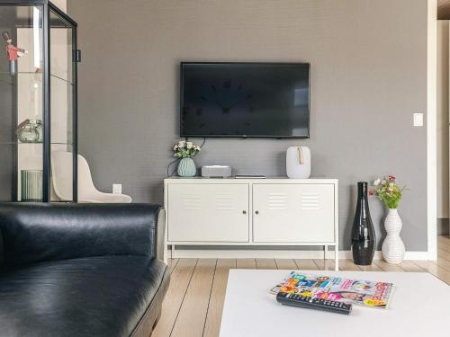 a living room with a couch and a flat screen tv at 8 person holiday home in Skagen-By Traum in Skagen