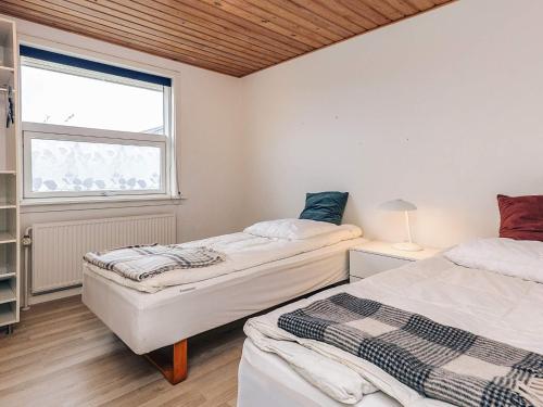 Dos camas en una habitación con ventana. en 9 person holiday home in Skagen, en Skagen