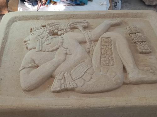 a sand sculpture of a man holding a basket at Hotel - Museo Xibalba in Palenque