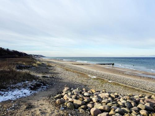 a beach with a bunch of rocks on it at 6 person holiday home in Græsted-By Traum in Græsted