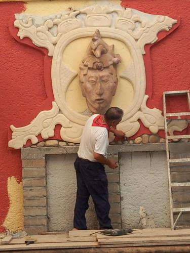 a man standing in front of a wall with a statue at Hotel - Museo Xibalba in Palenque