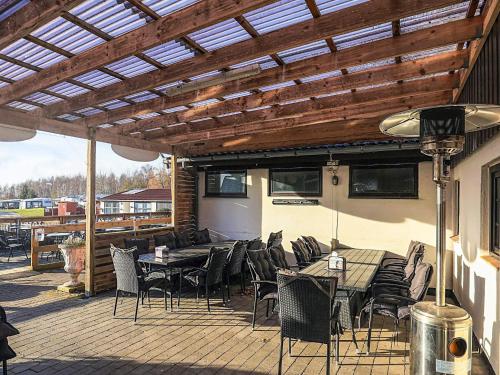 a patio with tables and chairs under a wooden pergola at 3 person holiday park home in Gørlev in Gørlev