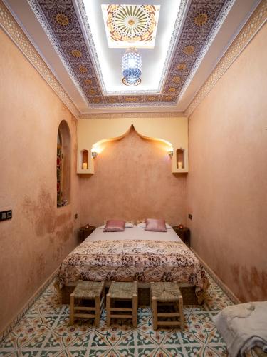 a bedroom with a bed in a room with a ceiling at Riad Qasr El Medina in Tangier