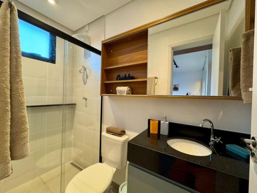 Un baño con inodoro, lavabo y espejo. en Studio 305 with panoramic pool - close to USP, en São Carlos
