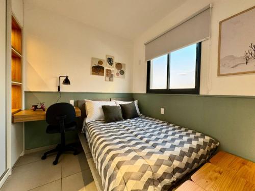 Un dormitorio con una cama y un escritorio y una ventana. en Studio 305 with panoramic pool - close to USP, en São Carlos