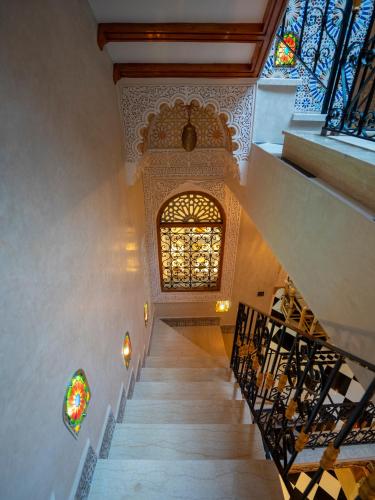 a staircase in a building with a stained glass window at Riad Qasr El Medina in Tangier
