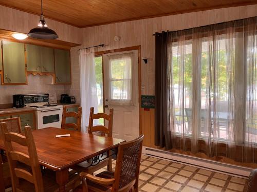 a kitchen with a wooden table and a dining room at Camping Chalets Lac St-Augustin in Quebec City