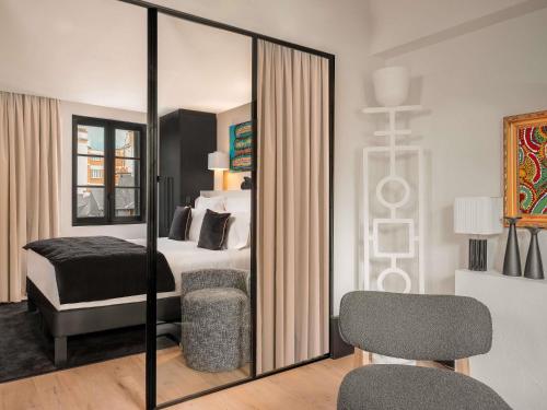 a hotel room with a bed and a mirror at Balthazar Hotel & Spa Rennes - MGallery Collection in Rennes