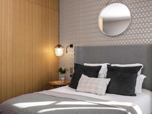 a bedroom with a bed with a mirror on the wall at Balthazar Hotel & Spa Rennes - MGallery Collection in Rennes