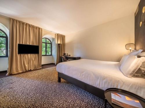 a hotel room with a bed and a television at La Citadelle Hotel Metz - MGallery Collection in Metz