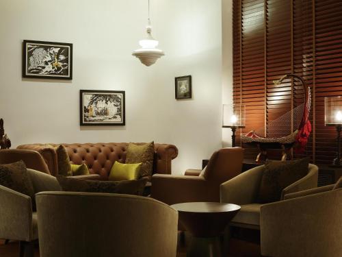 a living room with a couch and chairs and a table at The Lake Garden Hotel Nay Pyi Taw - MGallery Collection in Nay Pyi Taw