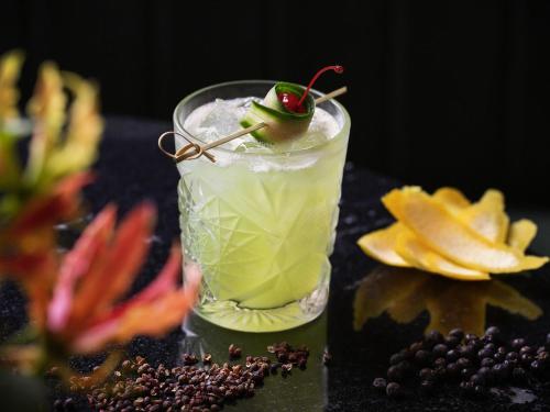 a drink with a cherry on a table with fruit at Sofitel Wellington in Wellington
