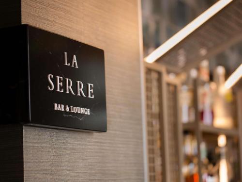 a sign on a wall that reads la serre bar and lounge at Sofitel Wellington in Wellington