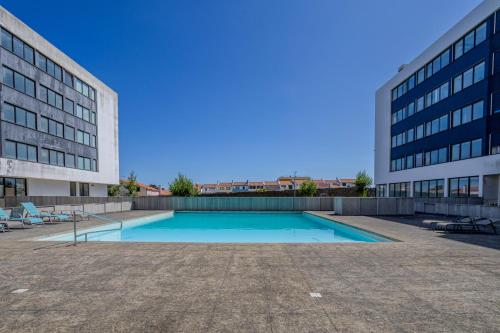 a swimming pool in front of a building at Neat Apartment in Ponta Delgada