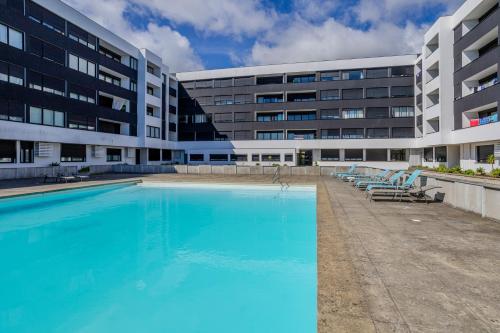 a large swimming pool in front of a building at Neat Apartment in Ponta Delgada
