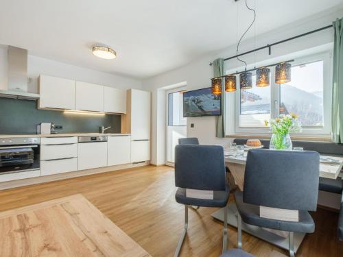 a kitchen with white cabinets and a table and chairs at Roßbrand und Tauern-Blick in Untertauern