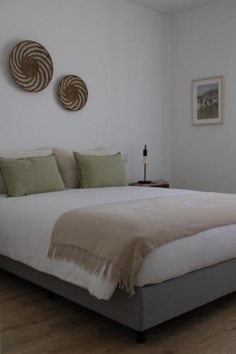 Un dormitorio blanco con una cama grande con dos almohadas. en Alto Mar Apartment 2, en Atouguia da Baleia