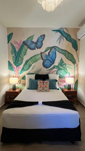 a bedroom with a bed with a mural of butterflies at Casa Mexico Lindo - Boutique Hostel in Bacalar