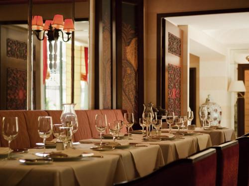 a long table with wine glasses on it at Royal Hotel Oran - MGallery Collection in Oran