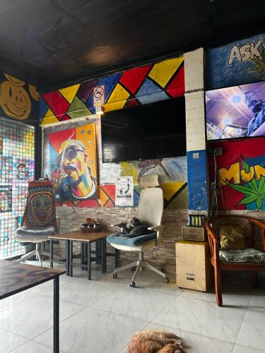a room with paintings on a wall with tables and chairs at Munchies Bed & Breakfast in Bangkok