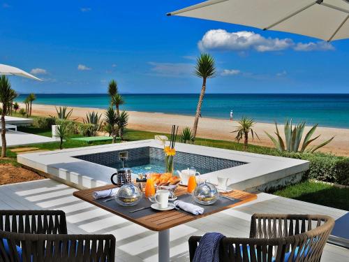 a table with food on it with a view of the beach at Sofitel Tamuda Bay Beach And Spa in M'diq