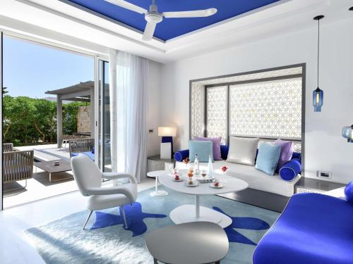a living room with blue and white furniture at Sofitel Tamuda Bay Beach And Spa in M'diq