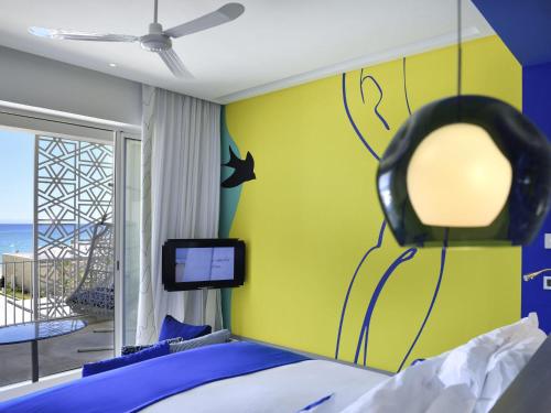 a bedroom with a bed with a mirror on the wall at Sofitel Tamuda Bay Beach And Spa in M'diq