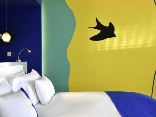 a bedroom with a bed with a bird on the wall at Sofitel Tamuda Bay Beach And Spa in M'diq