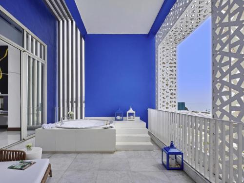 a bathroom with a tub and a blue wall at Sofitel Tamuda Bay Beach And Spa in M'diq