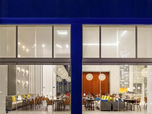 a dining room with tables and chairs and windows at Sofitel Tamuda Bay Beach And Spa in M'diq