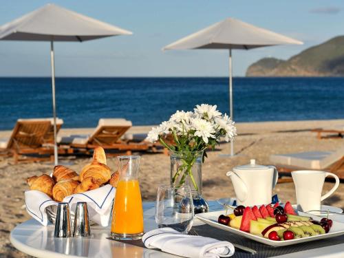 a table with a plate of food on the beach at Sofitel Tamuda Bay Beach And Spa in M'diq