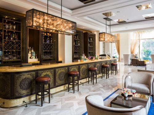 a bar at a hotel with bar stools at Hotel Des Arts Saigon Mgallery Collection in Ho Chi Minh City