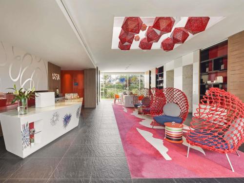 a lobby with red chairs and a pink rug at Sofitel Tamuda Bay Beach And Spa in M'diq
