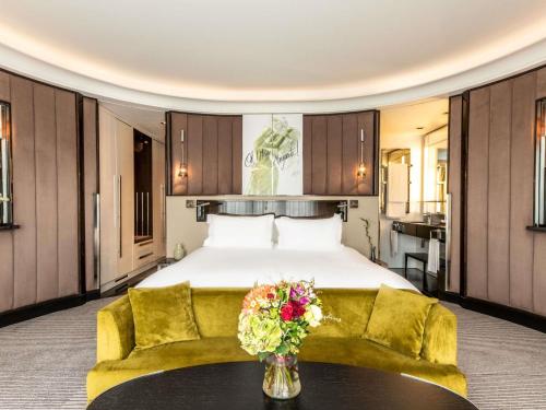 a bedroom with a bed and a vase of flowers on a table at Sofitel Frankfurt Opera in Frankfurt/Main