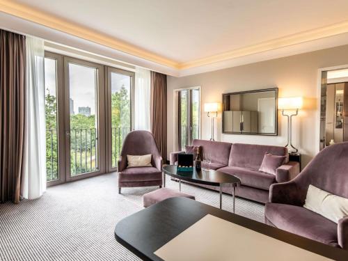 a living room with a couch and a table at Sofitel Frankfurt Opera in Frankfurt/Main