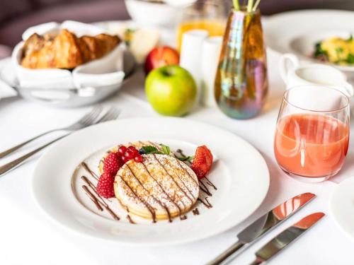 a white table with a plate of food and fruit at Sofitel Frankfurt Opera in Frankfurt/Main