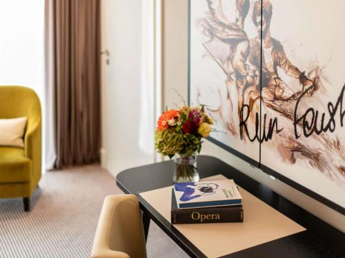 a vase of flowers on a table in a room at Sofitel Frankfurt Opera in Frankfurt/Main