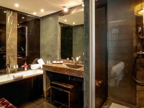 a bathroom with a large sink and a shower at La Cour des Consuls Hotel & Spa Toulouse - MGallery Collection in Toulouse
