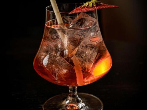 a drink in a glass on a table at La Cour des Consuls Hotel & Spa Toulouse - MGallery Collection in Toulouse