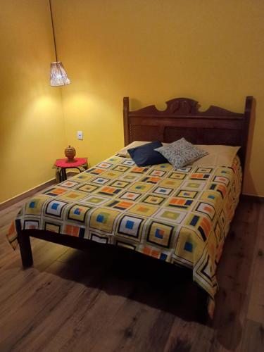 a bed with a colorful comforter in a bedroom at Chalé Arminda Costa in Ouro Preto