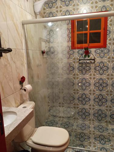 a small bathroom with a toilet and a shower at Chalé Arminda Costa in Ouro Preto