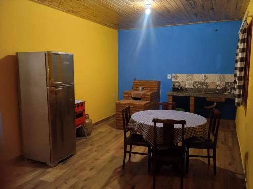 une cuisine avec une table et un réfrigérateur dans l'établissement Chalé Arminda Costa, à Ouro Preto