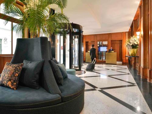 a living room with a couch in a lobby at l'Echiquier Opéra Hotel Paris - MGallery Collection in Paris