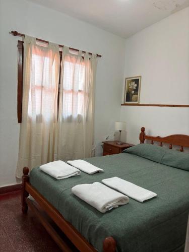 a bedroom with two beds with towels on them at Casa de Hugo in Cafayate