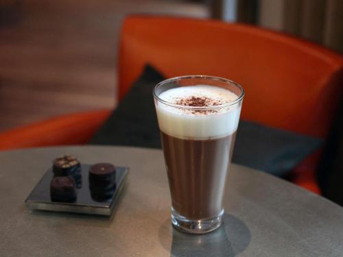 a glass of coffee sitting on top of a table at Boutet Bastille Hotel Paris - MGallery Collection in Paris
