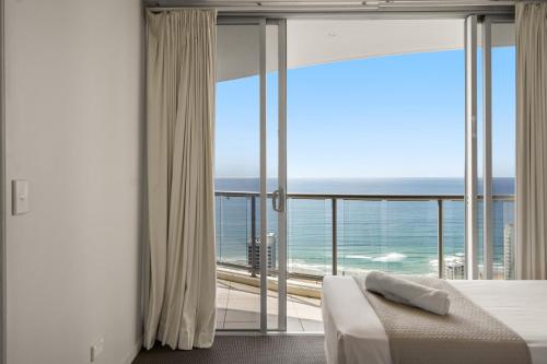 a bedroom with a bed and a view of the ocean at Chevron Renaissance - Private Apartments - Hosted by Coastal Letting Co. in Gold Coast