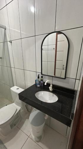 a bathroom with a sink and a toilet and a mirror at Pousada Ribeiro 2 in Belém